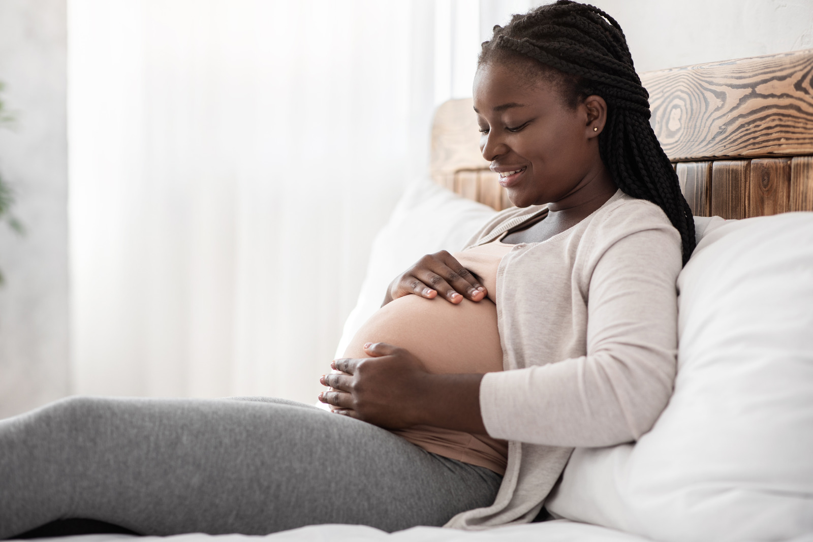Black Pregnant Woman Relaxing On Bed At Home